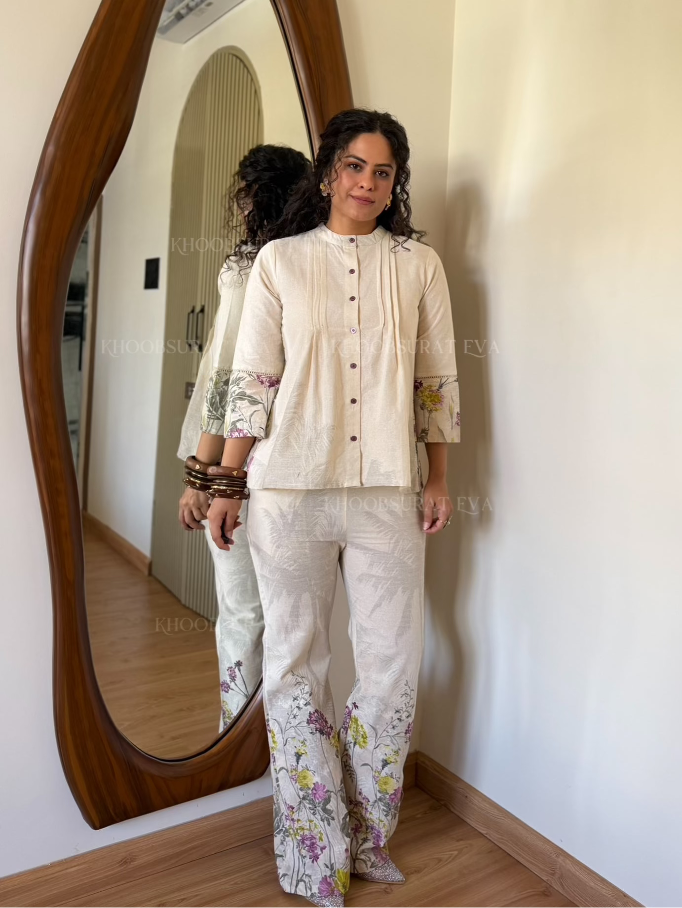 Woman standing in front of a large, wavy mirror wearing summer white coord set
