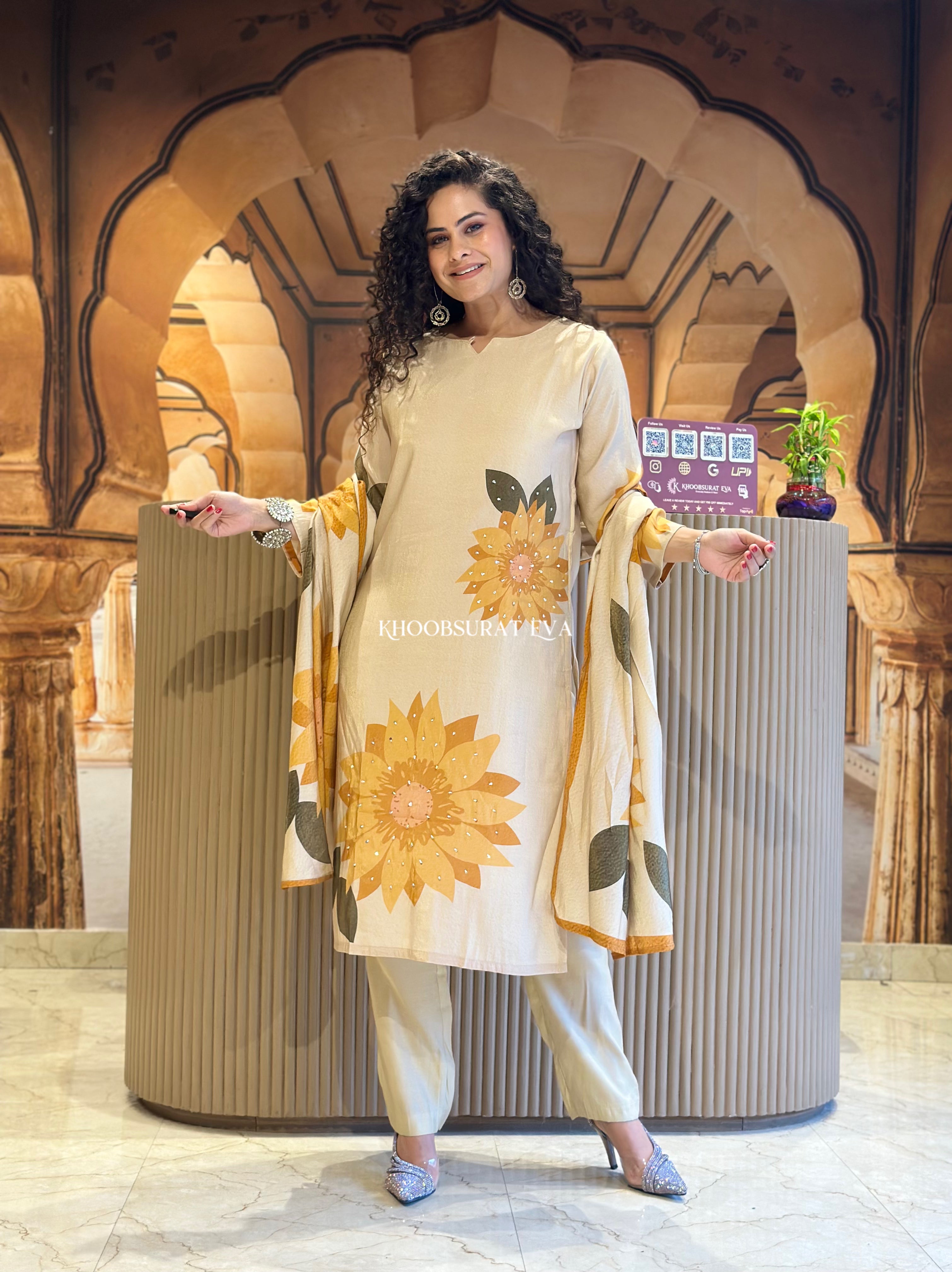 Woman in a floral outfit standing in front of an ornate archway