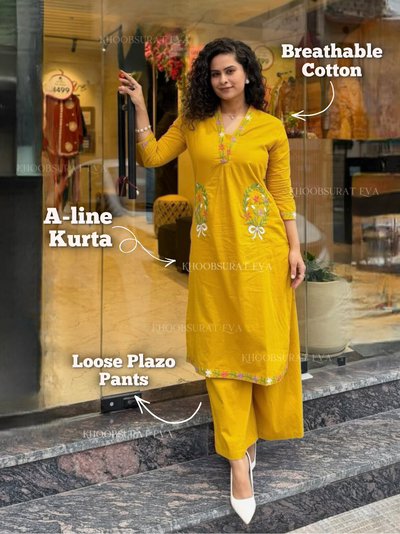 Woman in a yellow A-line kurta with loose plazo pants standing in front of a store entrance.